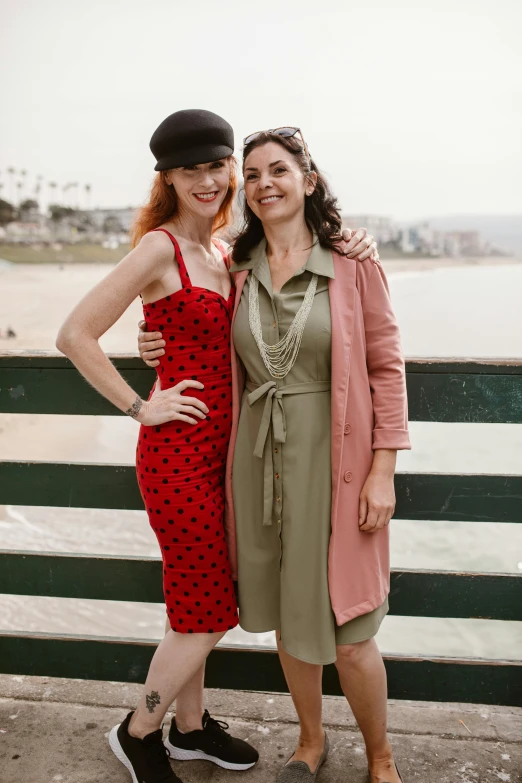 two women standing next to each other on a beach