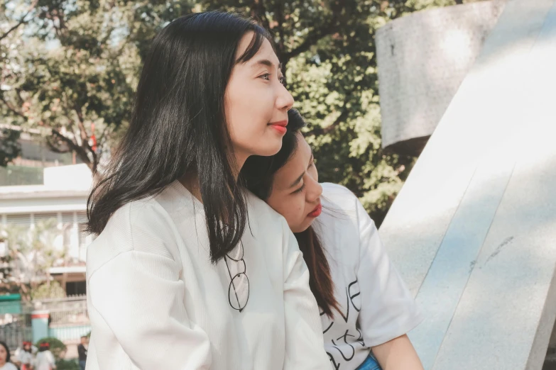 two women sitting on the edge of an outdoor slide