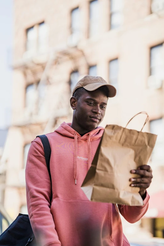 a young man wearing a hat carrying shopping bags