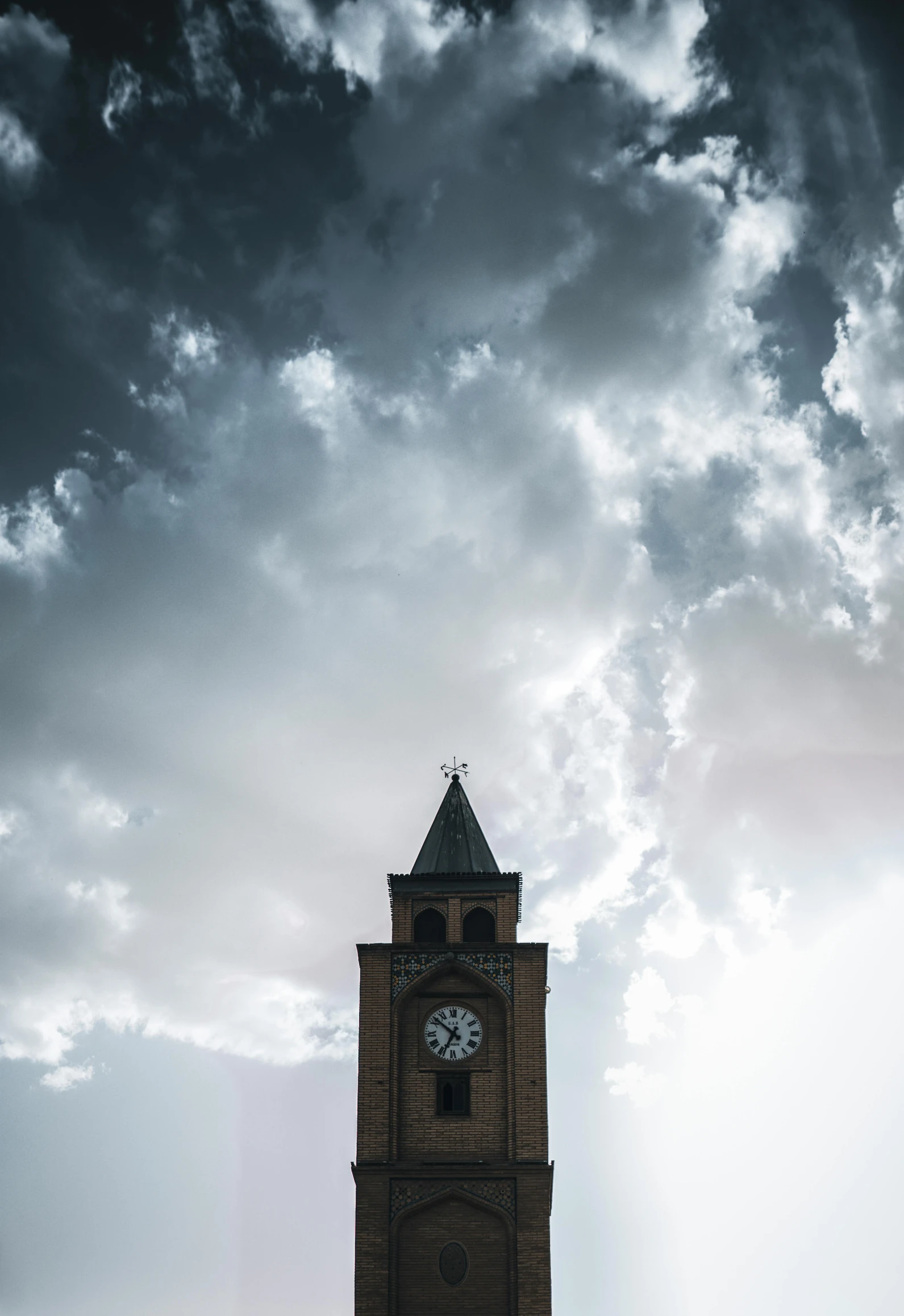 a very tall clock tower under some clouds