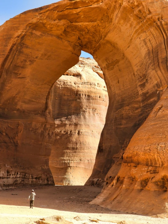 an image of a man in the desert with the arch in the background