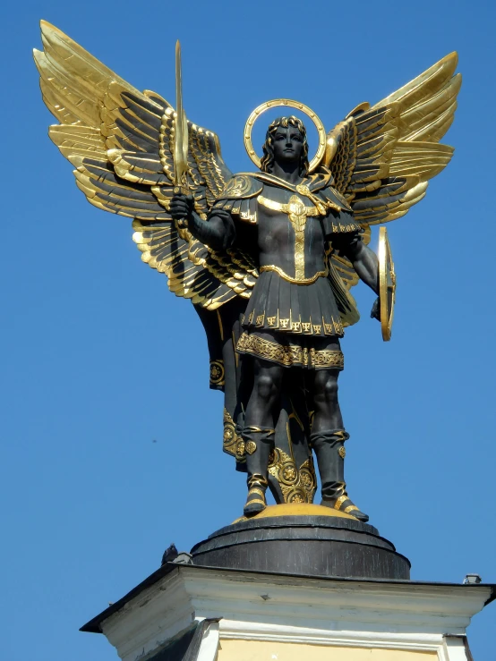 an angel statue stands in the sky on top of a tower