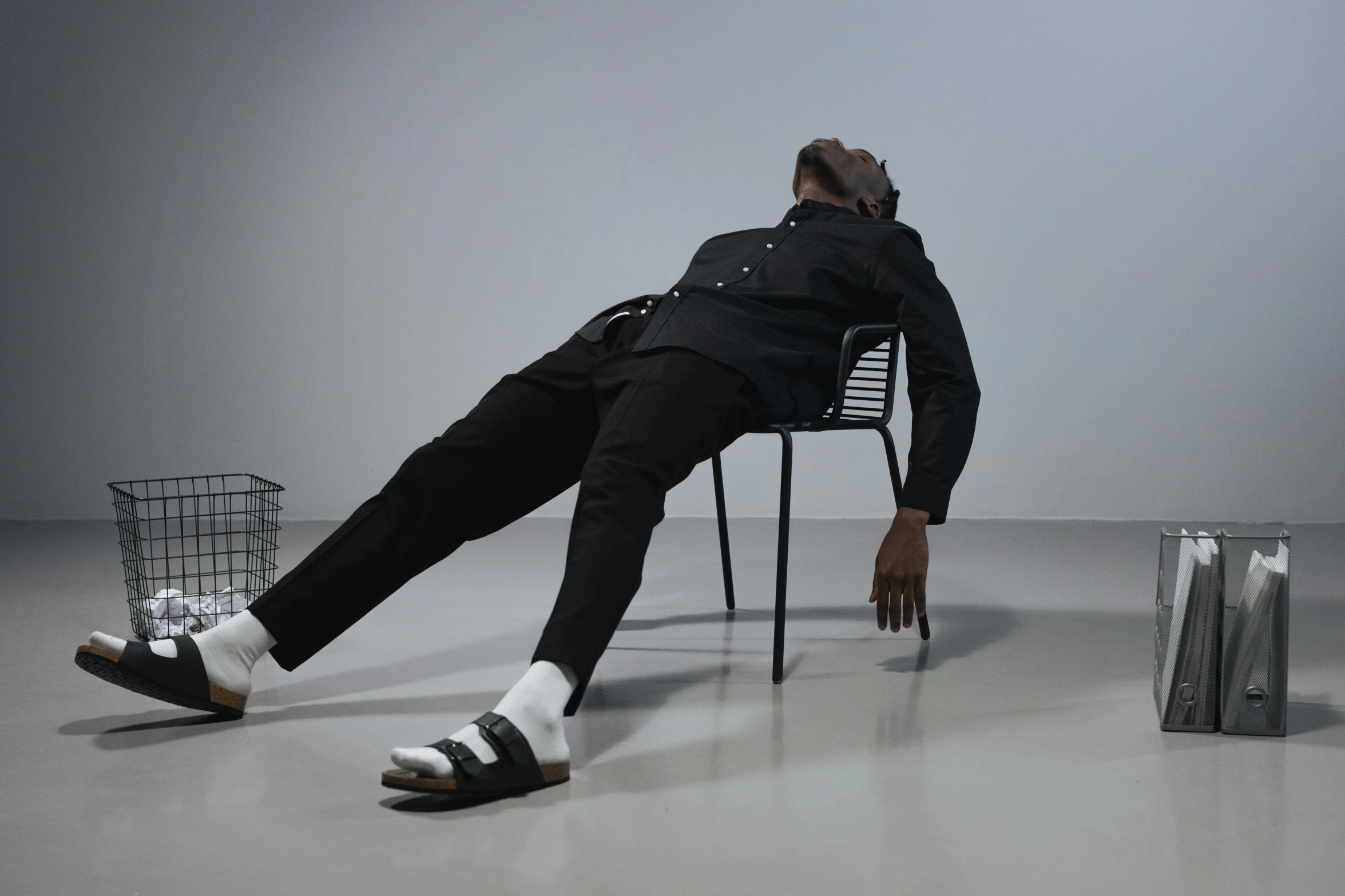 man in black jacket and white socks sitting on a chair