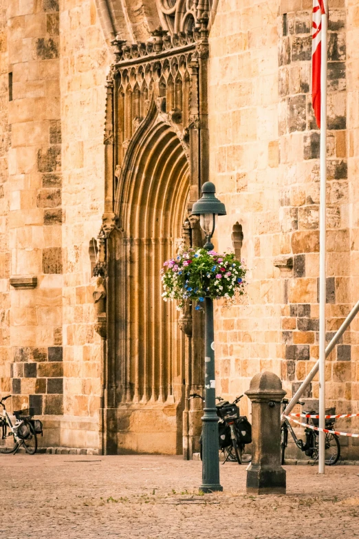 a light pole with flowers in it on the side of the street