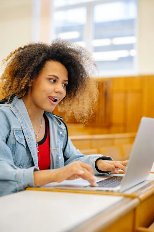 girl in lecture hall with laptop and surprised