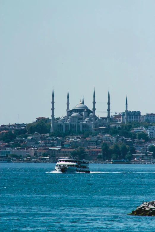 a small boat travels past the shore near a city