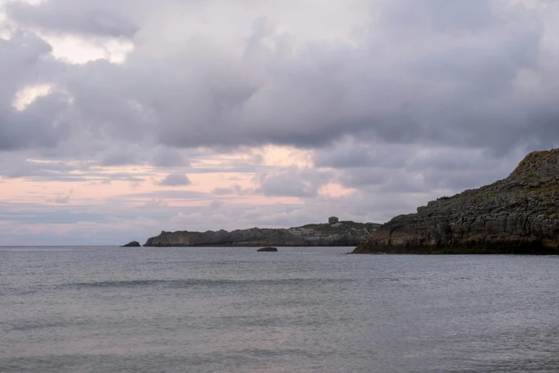 dark cloudy skies over a bay and an island