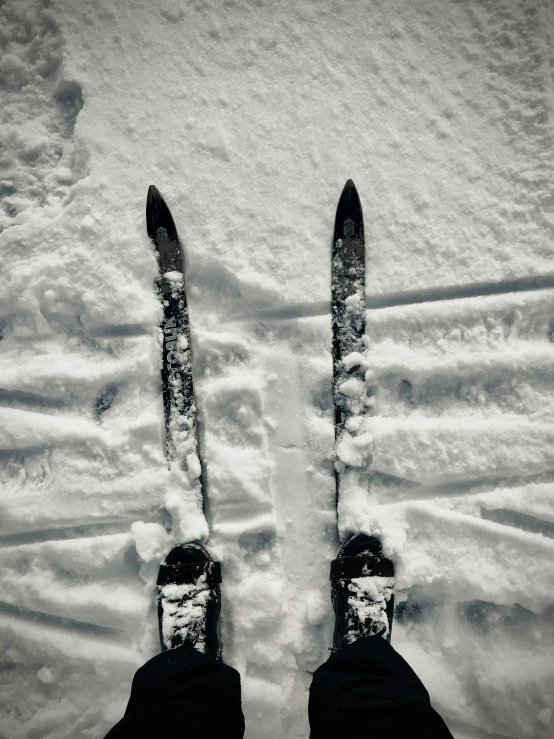 view down at legs, feet, and skis from a persons perspective