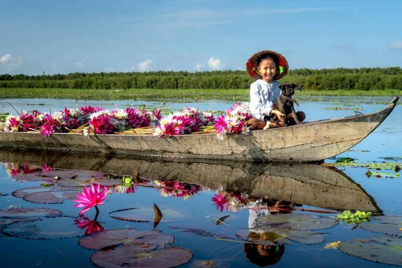 a woman and her dog paddling a boat with flowers