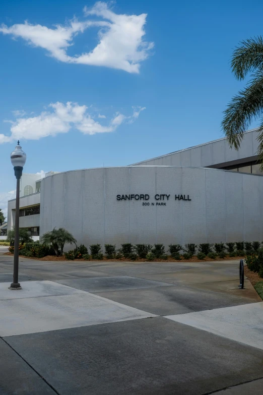 a gray building with a clock next to it