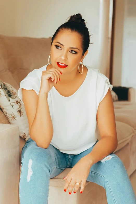 an attractive young woman sitting on top of a couch