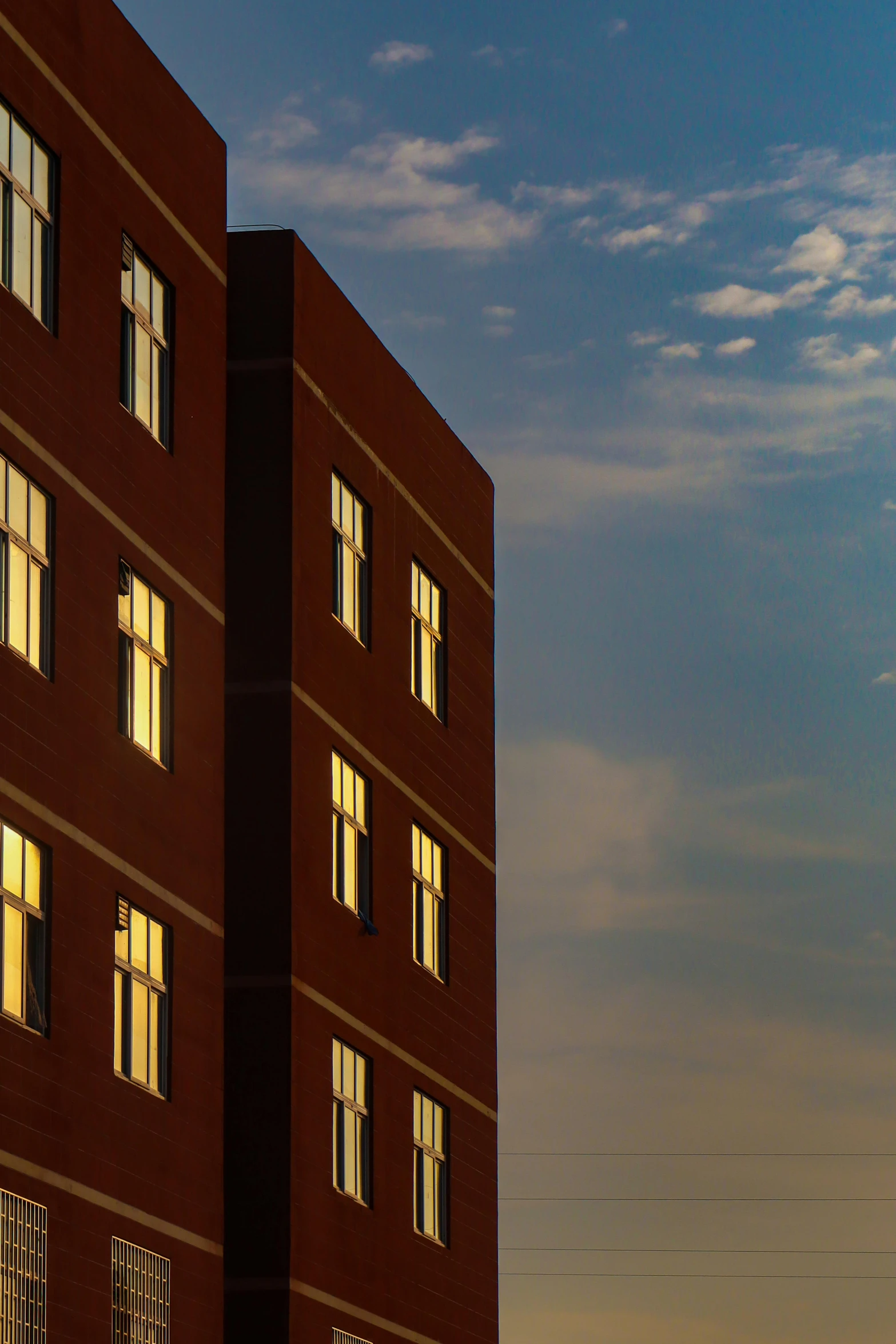 a tall brick building illuminated by two windows