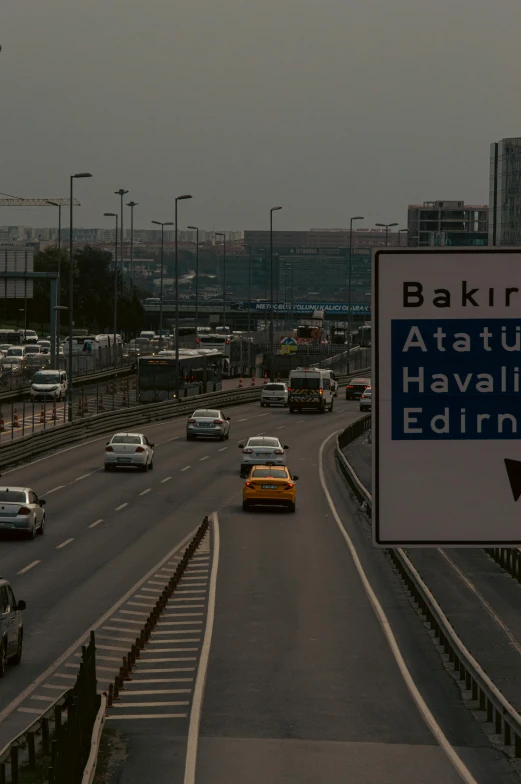 many cars on the road, with an all - weather sign in foreground