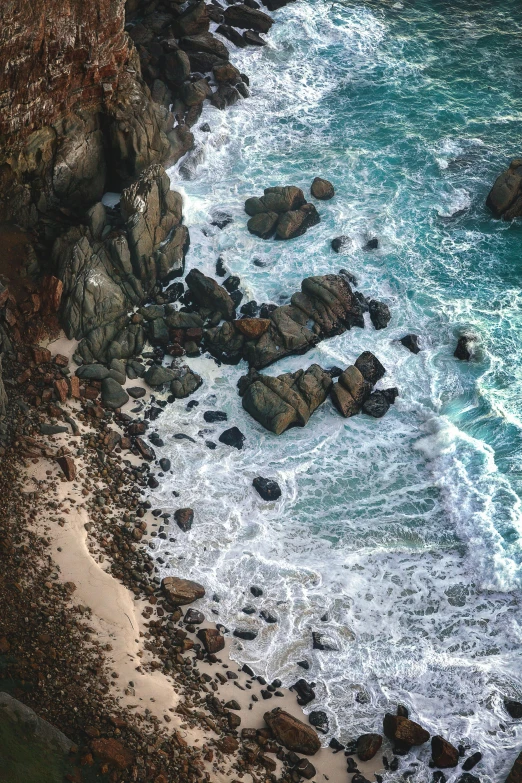 an aerial s of rocks, the shore and ocean
