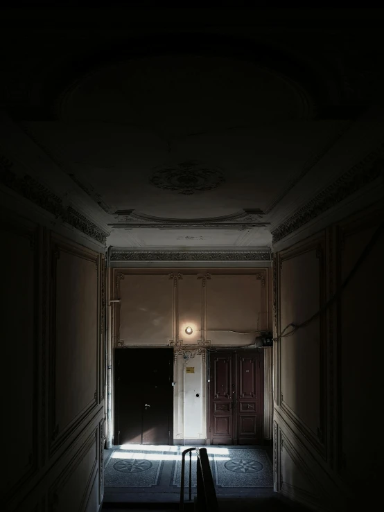 an empty room that is well lit by the light coming from the entrance