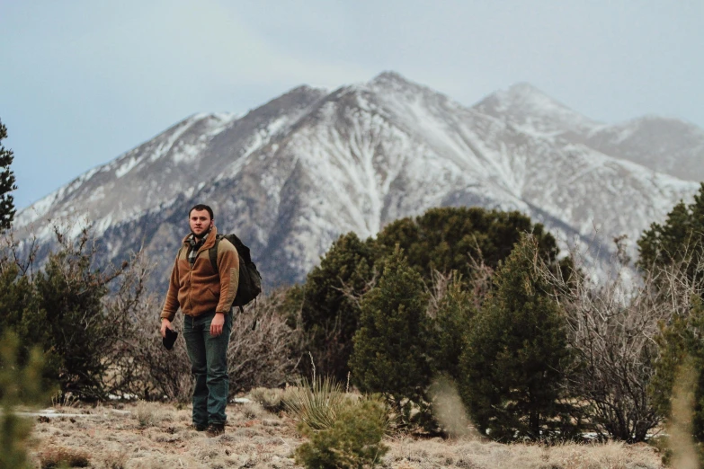 a man walking with a backpack in a wilderness