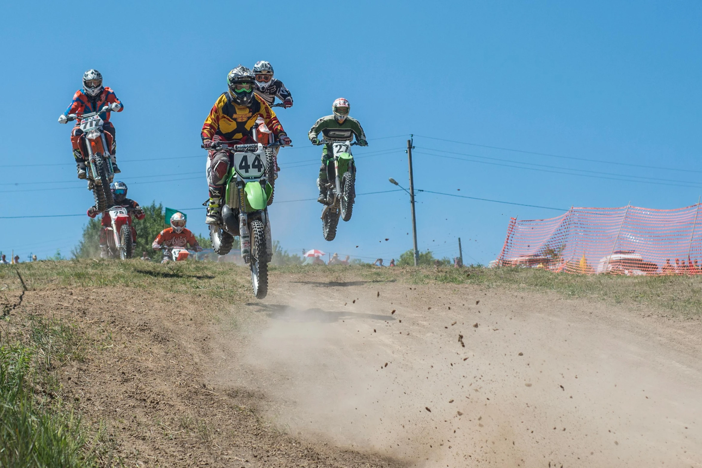 four dirt bikes racing on a dusty dirt road