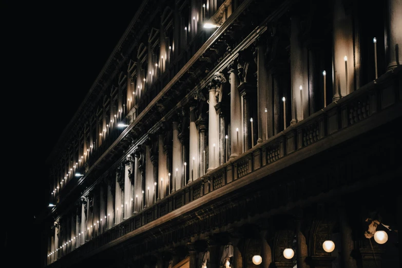 a row of lit lights on a building at night