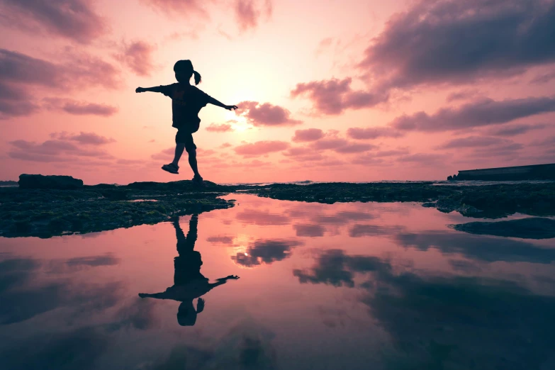 a silhouette of a  walking across a body of water