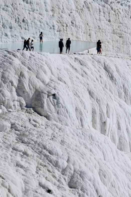 people on top of snow covered mountain near water