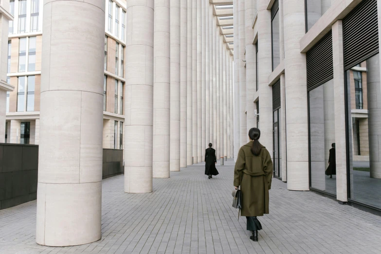 man in trench coat walking inside an outside mall