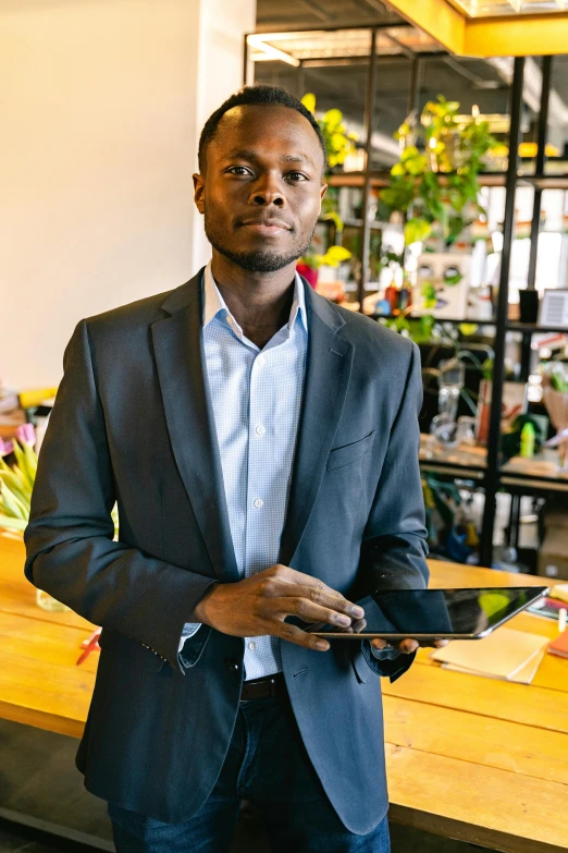 the man is standing behind his desk holding a small piece of paper