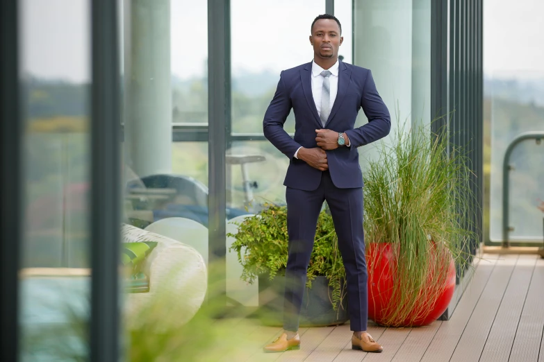 the man in a blue suit stands in front of a window