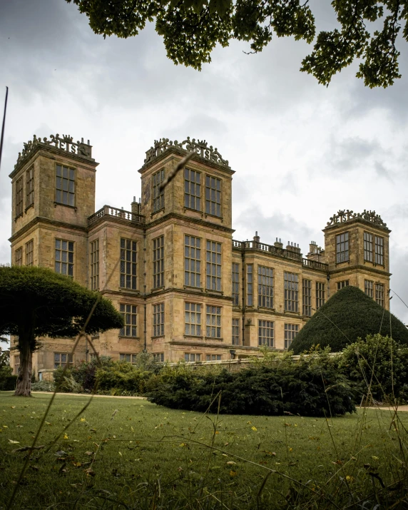 large building with towers and bushes in front