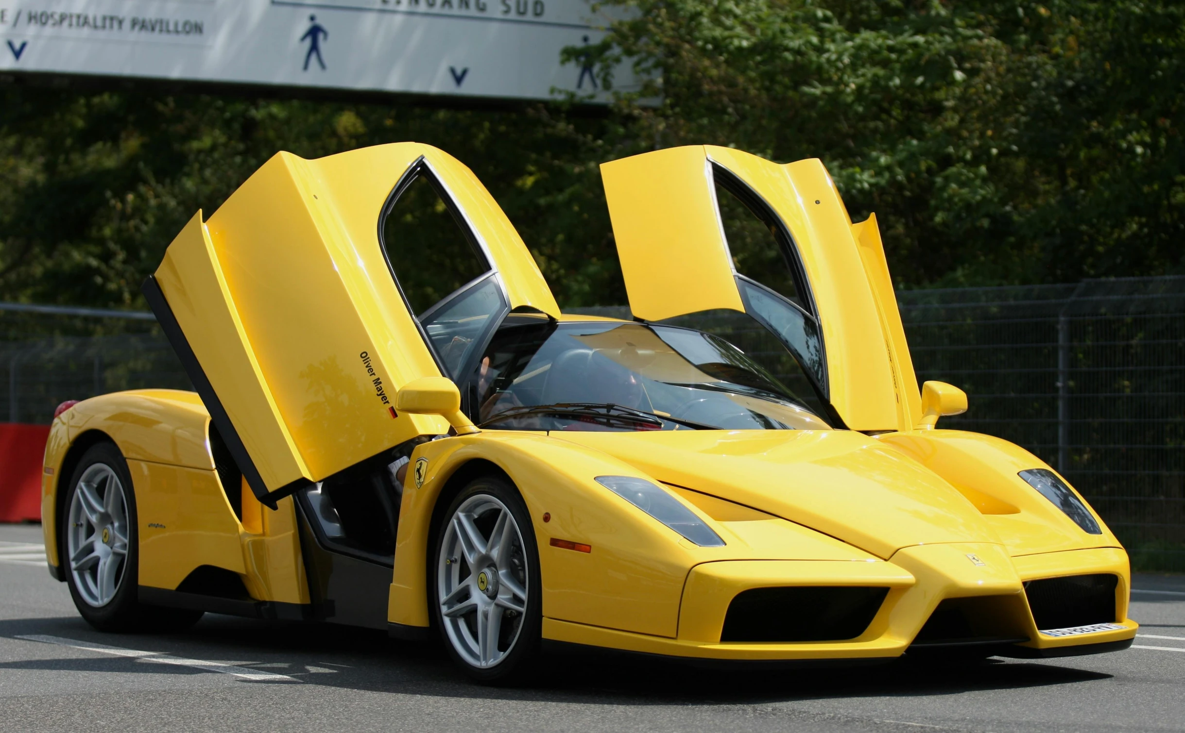 an yellow sports car has its doors open