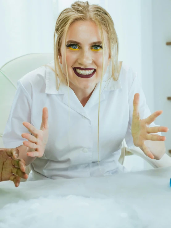 a beautiful blond lady with big smile sitting at a table