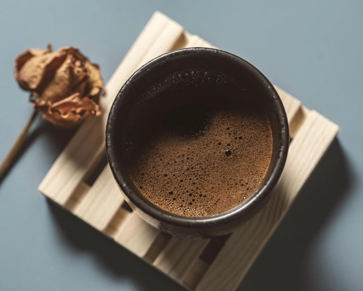 coffee on a coaster with a dried flower