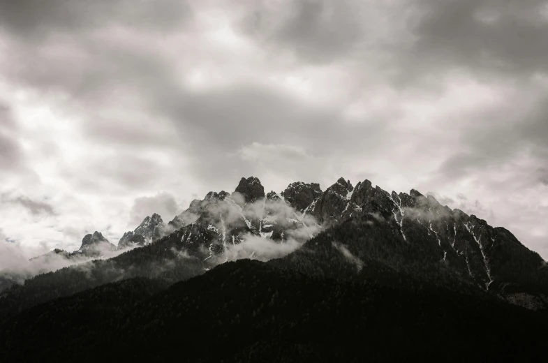 black and white po of mountains under stormy skies