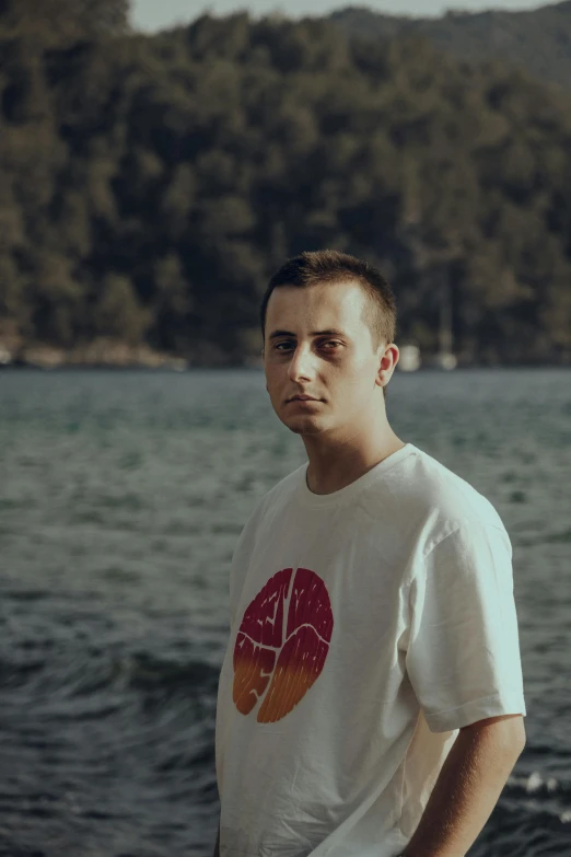 a guy standing in front of the ocean and trees