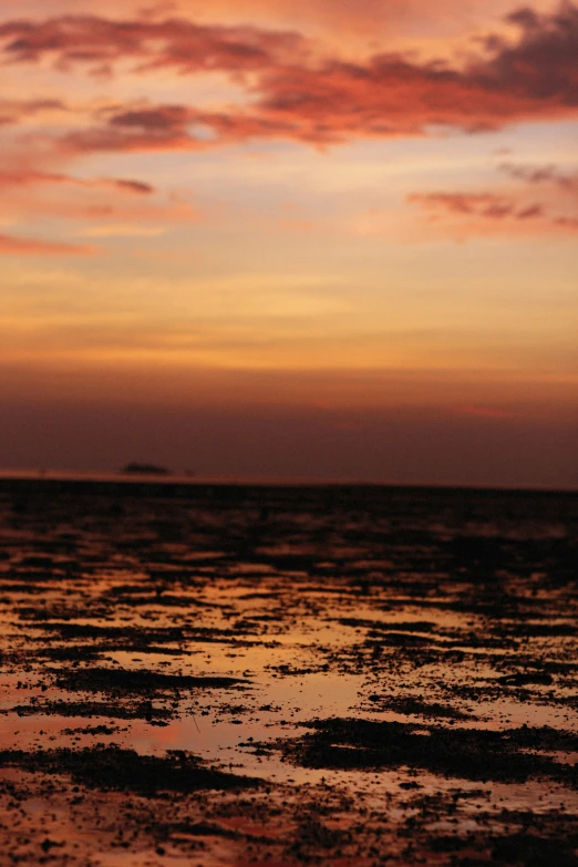 the orange and pink clouds over the ocean at sunset