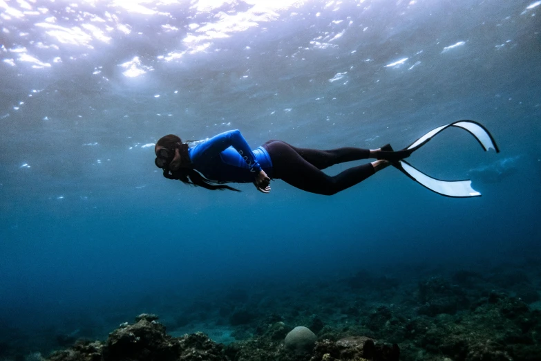 a woman is swimming in the ocean with a big white fin