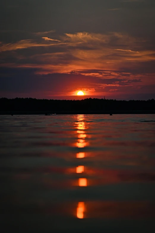 the sun rising over the horizon over the water