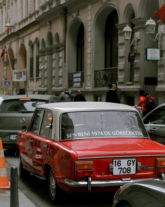 a red car parked in a lot near traffic cones