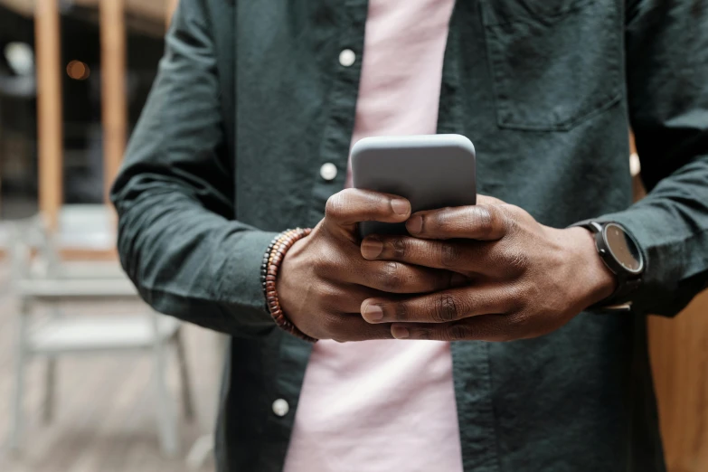 a man in pink shirt using a smart phone