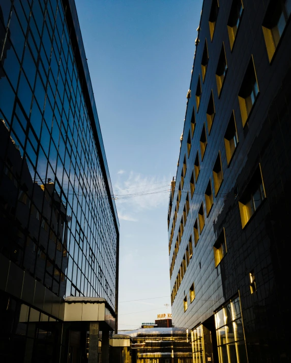 one view of two large buildings in the distance, some have black windows and one has yellow windows