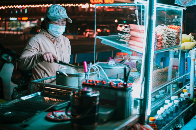 a woman standing at a food stand preparing food