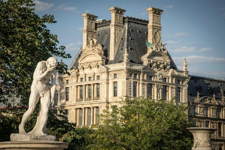 the statue is placed in front of the ornate building