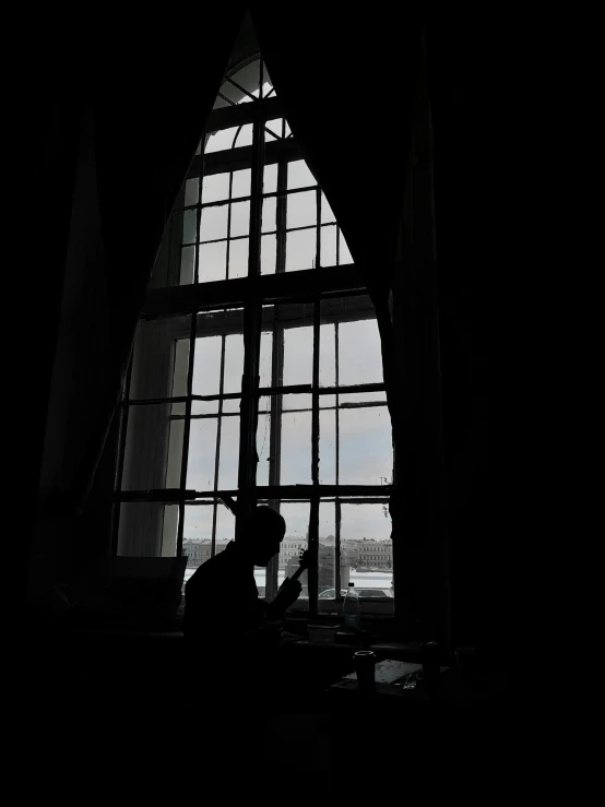 a person sits near a window and reads