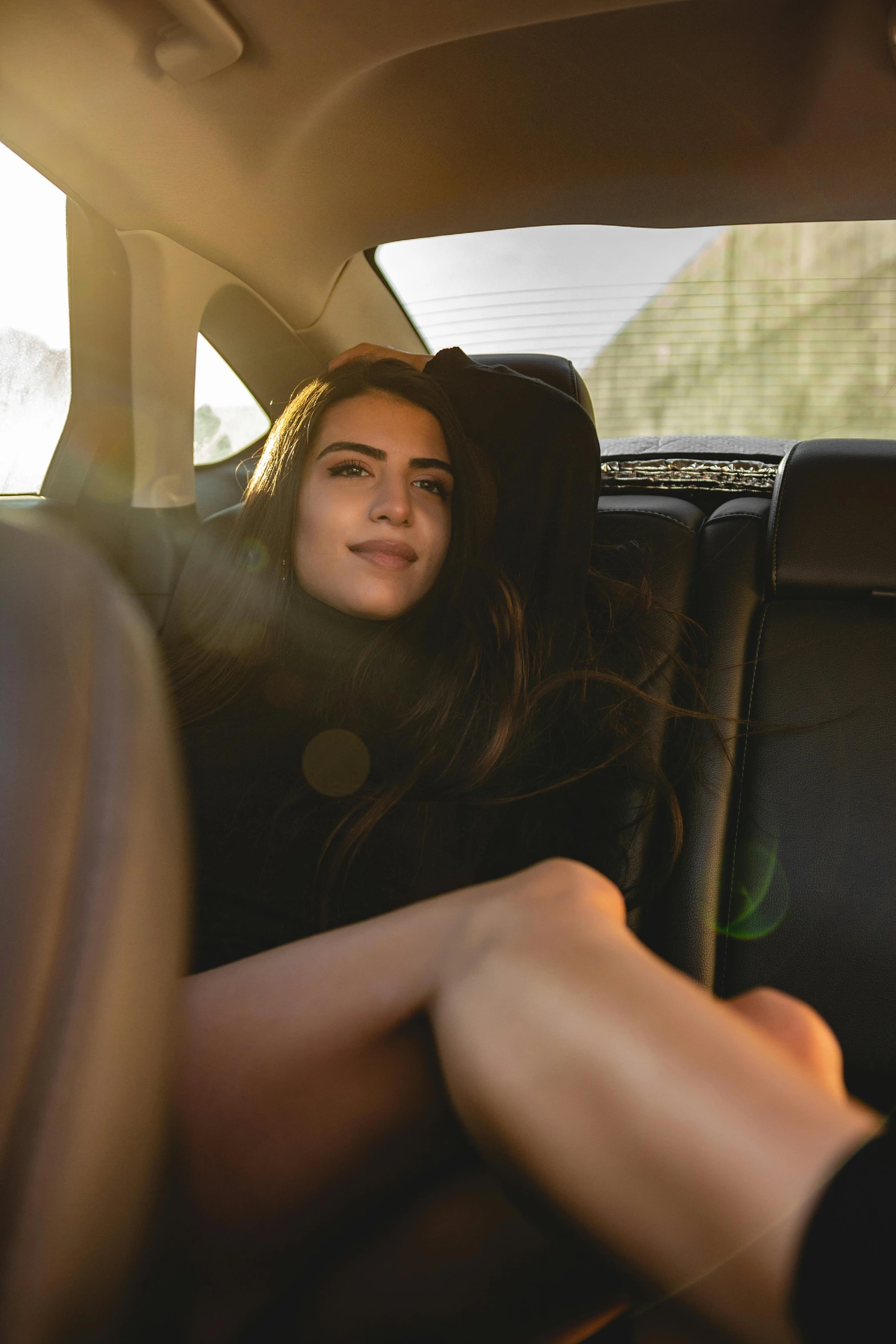 a woman sitting in the back of a car with her hands on the floor