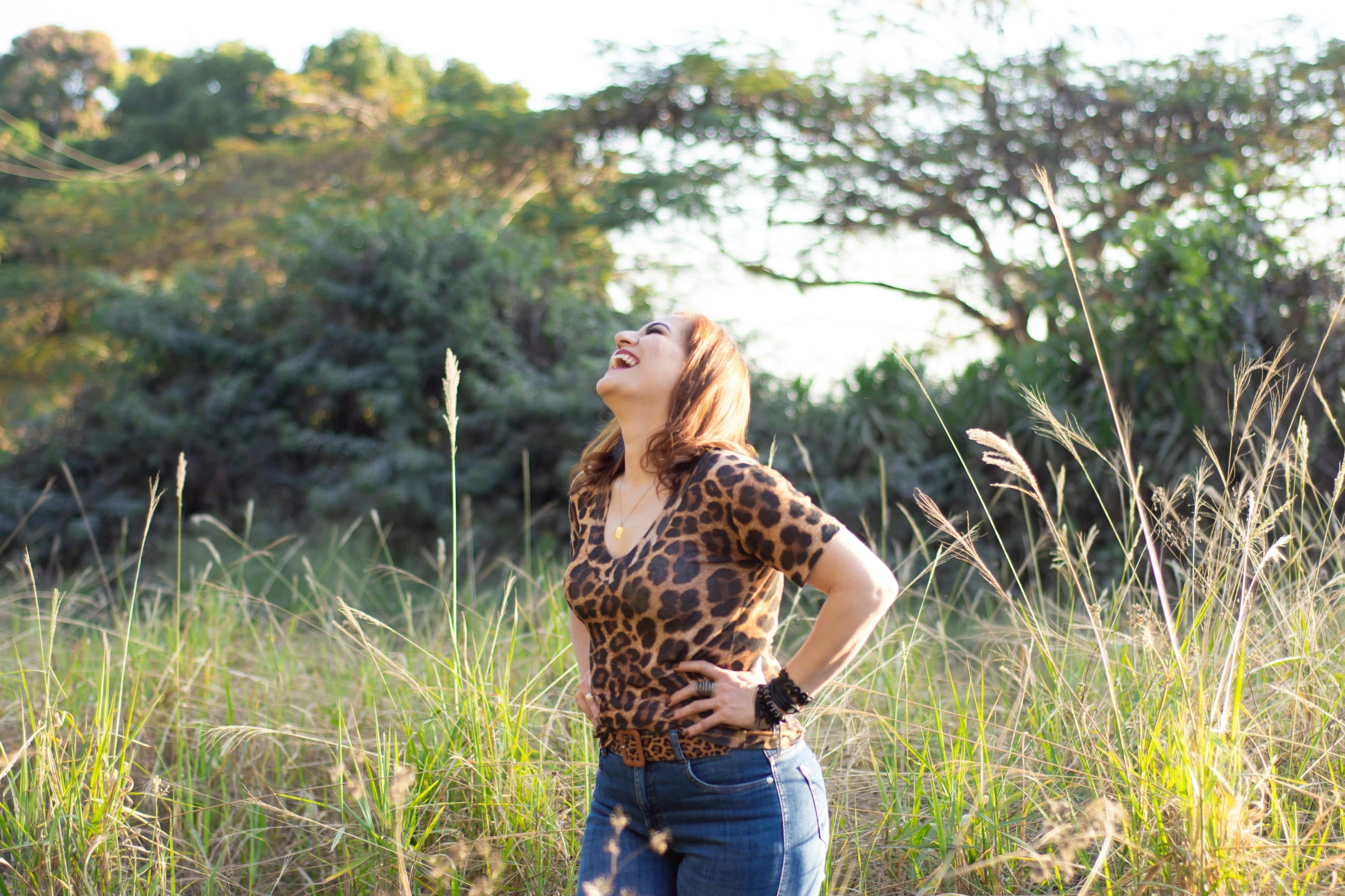 a lady in jeans standing in a field