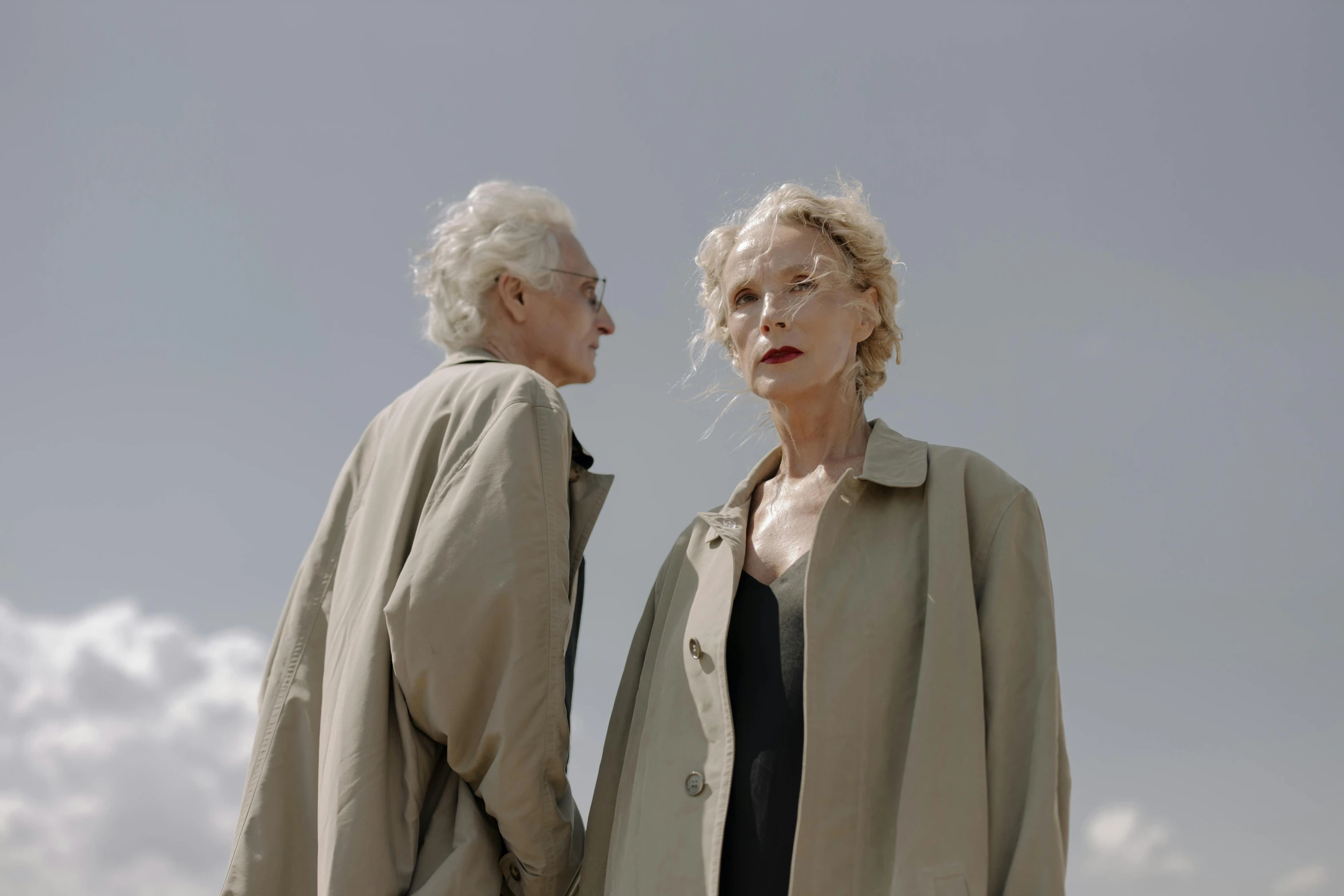 an older couple in white and black on a beach