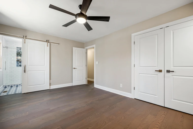 a room with wooden floors and white doors