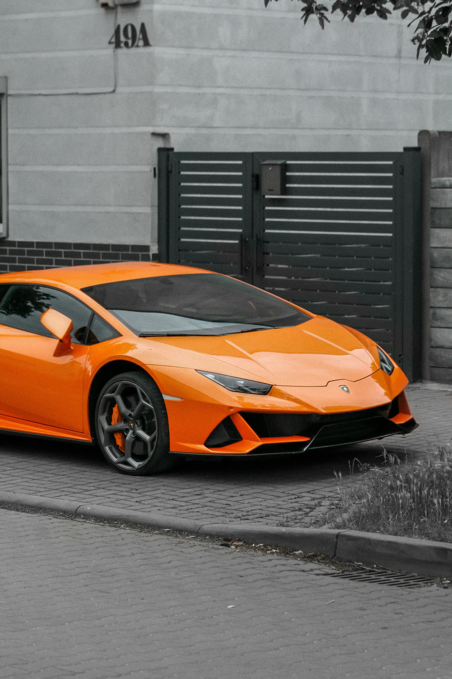 a bright orange lamb - based vehicle in front of an automated gate