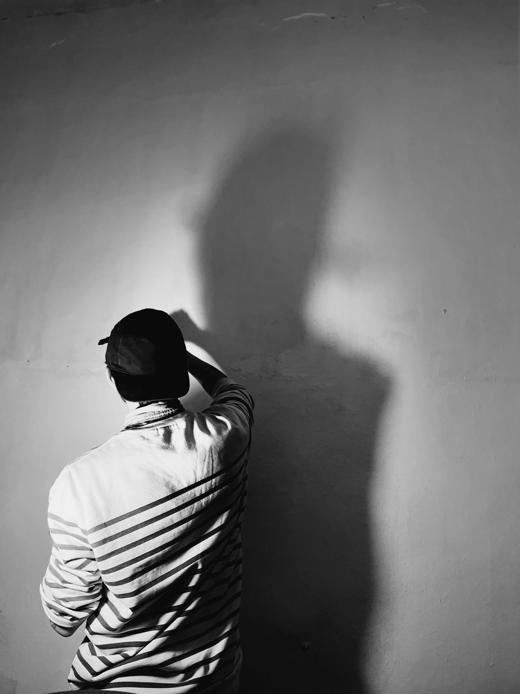 a man in white jacket standing against a wall