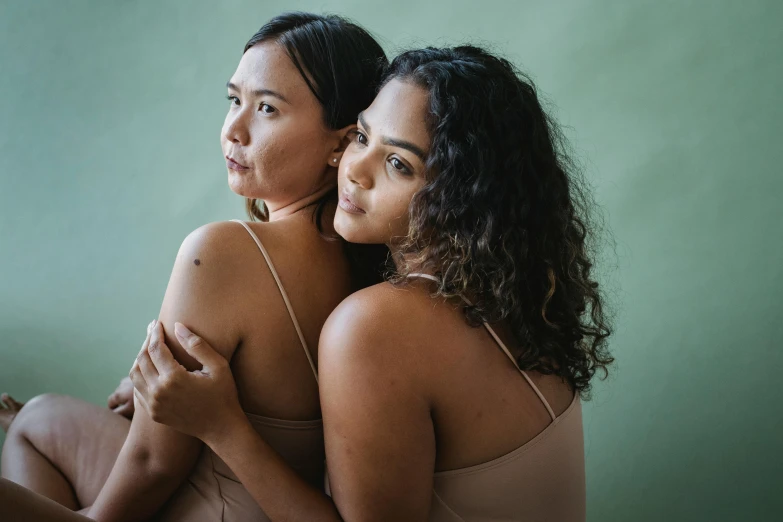 two women sitting on a bed together