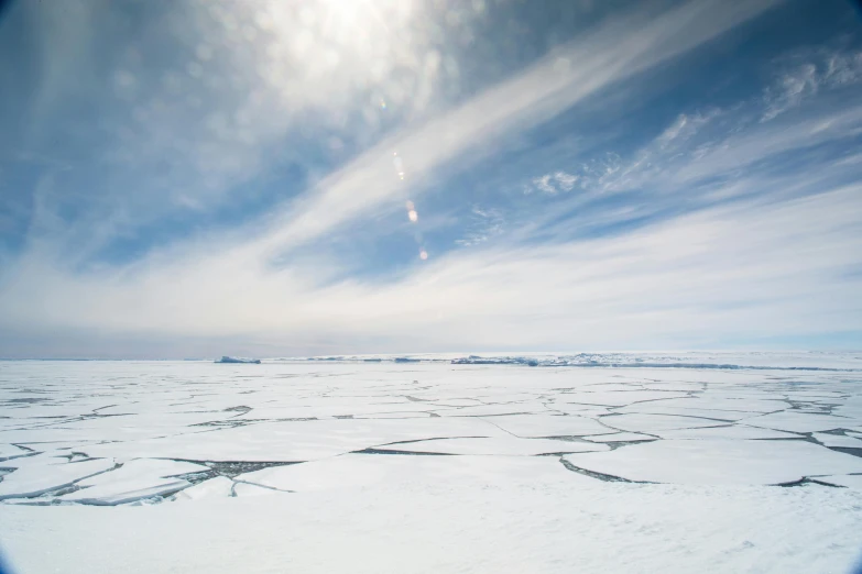 a white landscape covered in snow with the sun shining